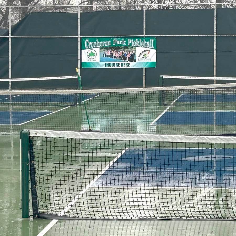 pickleball net strung across a wet outdoor court on a rainy day