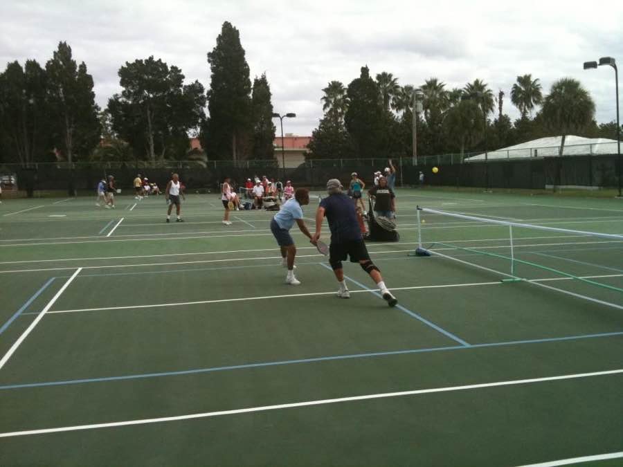players mid-rally on outdoor pickleball courts at a recreation centre