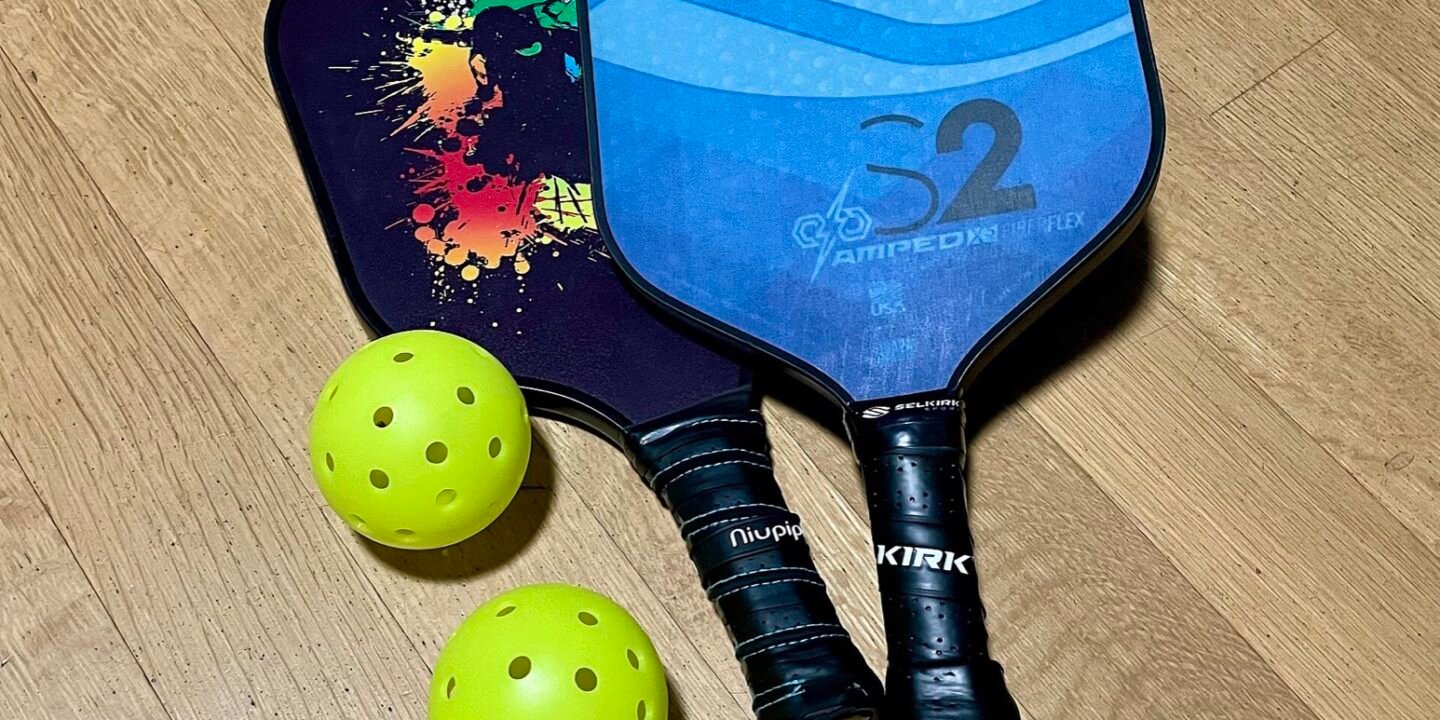 pickleball paddles and balls arranged together showing different face textures and finishes