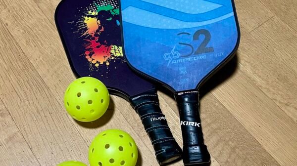 pickleball paddles and balls arranged together showing different face textures and finishes